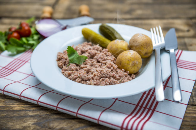 Plato tradicional de Weckewerk de la región de Hesse, al norte de Frankfurt, acompañado de patata cocida y pepinillos, una receta alemana típica ideal para turismo gastronómico