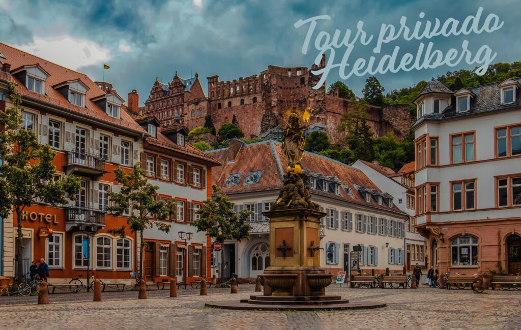 Plaza Kornmarkt de Heidelberg con la fuente de la Madonna, edificios históricos y el Castillo de Heidelberg al fondo – Tour Privado desde Frankfurt